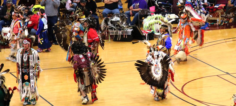A group of Native American dancers in full regalia