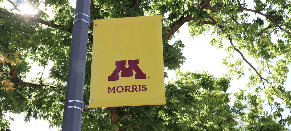 University of Minnesota Morris banner on a summer day with leaves in the background